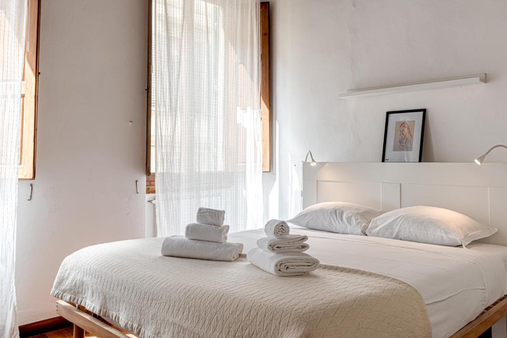 biała sypialnia z łóżkiem i ręcznikami w obiekcie Dieffe - Sweet Dreams in Florence we Florencji