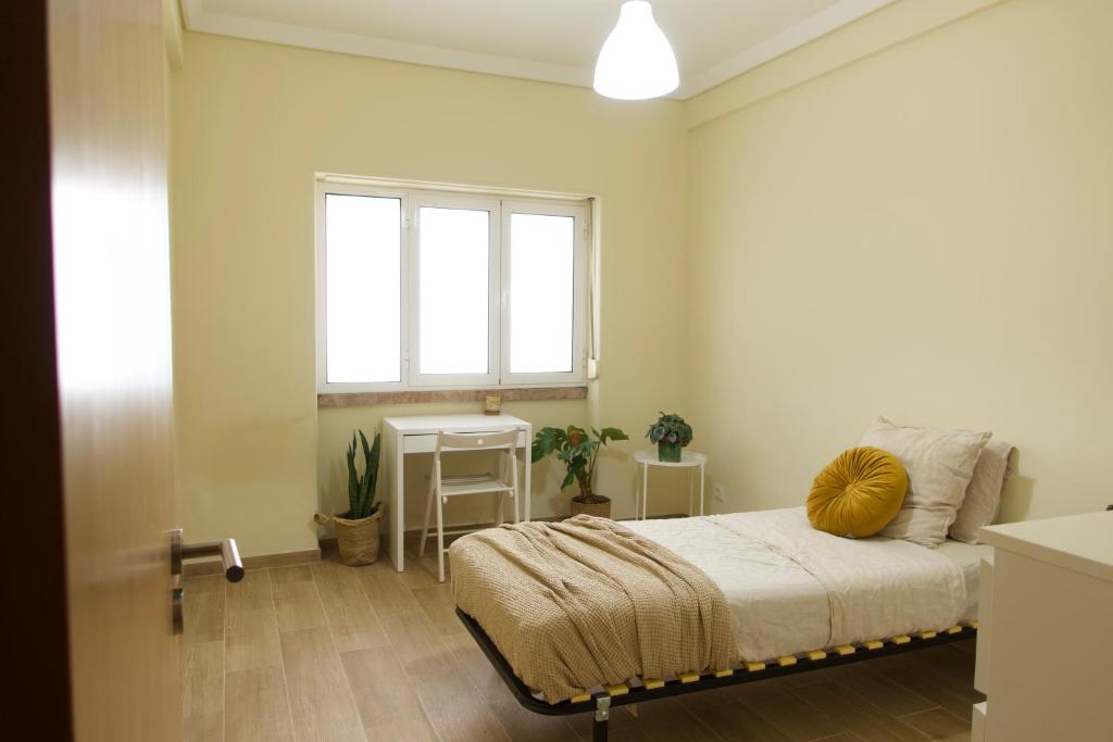 sypialnia z łóżkiem i oknem w obiekcie Lisbon Key Hub - Rooms 1-5 w Lizbonie