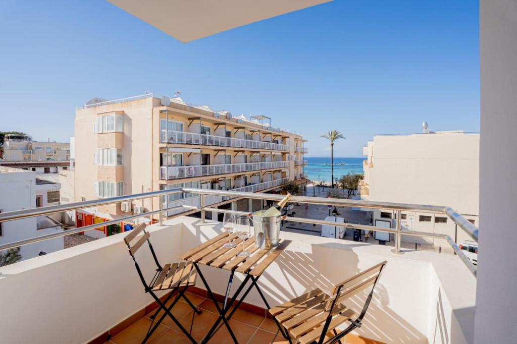 uma varanda com 2 cadeiras e vista para o oceano em Apartamentos Turisticos CAN CUNILL em Es Pujols