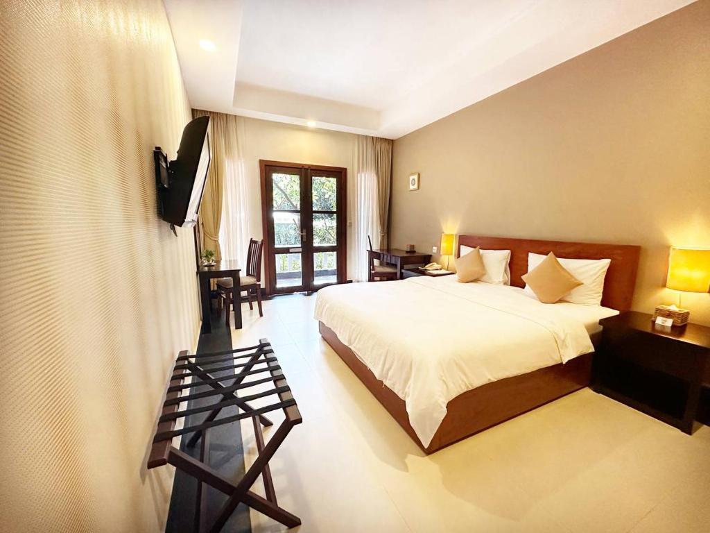 a bedroom with a bed and a flat screen tv at Skyline Boutique Hotel Phnom Penh in Phnom Penh