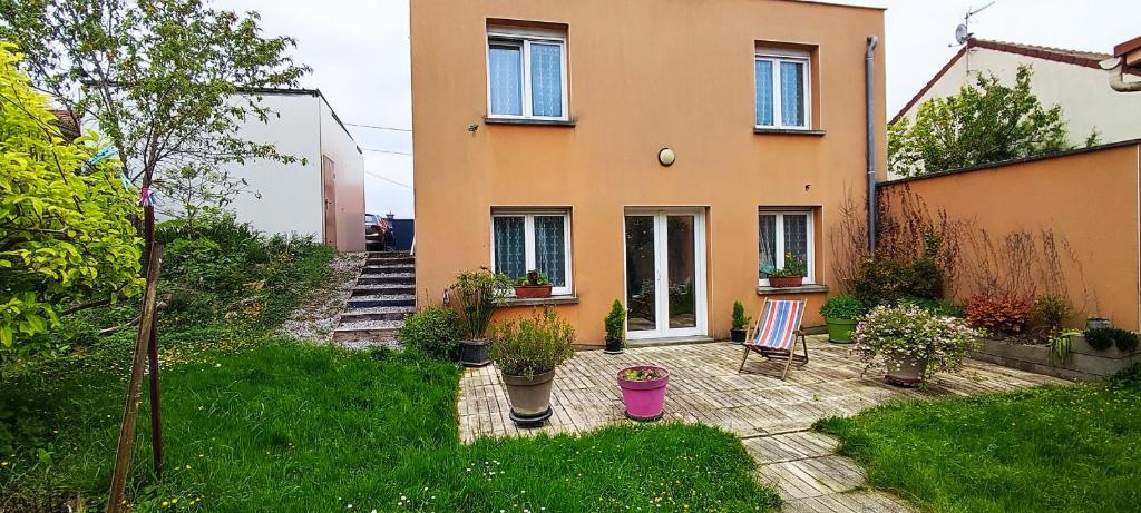 uma casa com um jardim em frente em LE NID chez Agnès et Théo, au calme avec jardin, à 10mn de la cathédrale em Reims