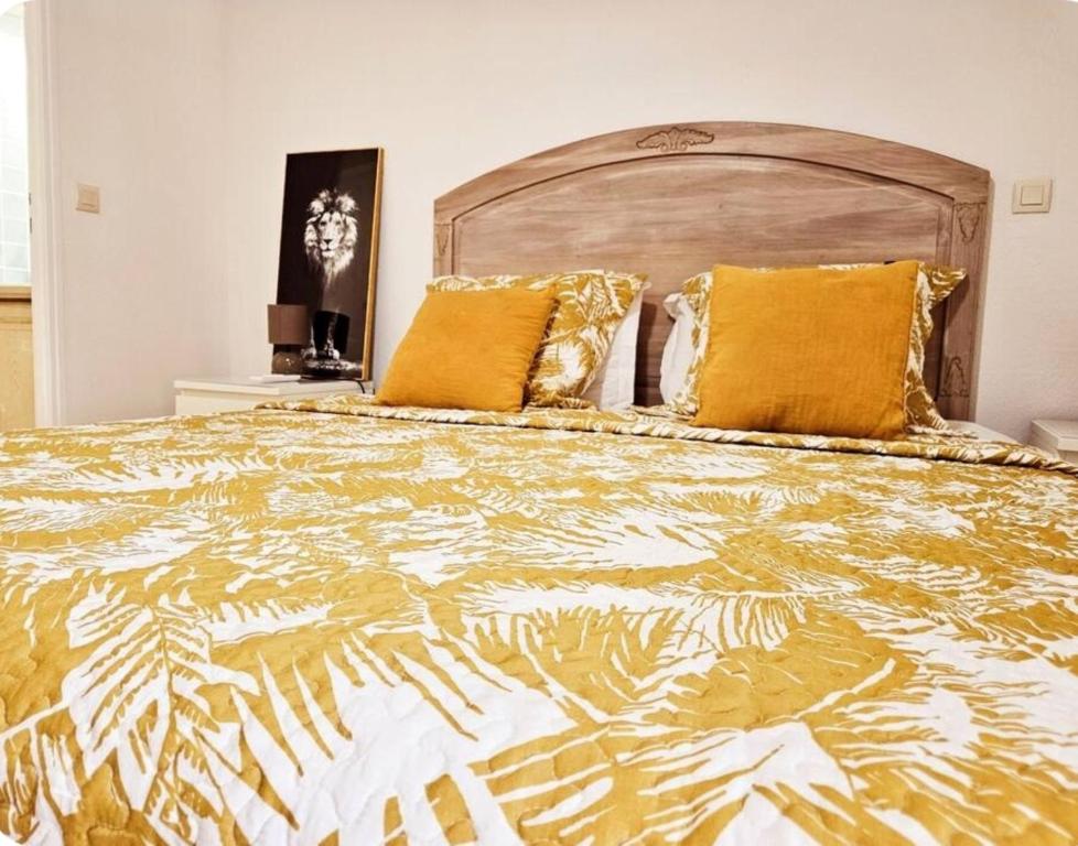 ein Schlafzimmer mit einem großen Bett mit gelben Kissen in der Unterkunft Maison Casanova in Orient Bay