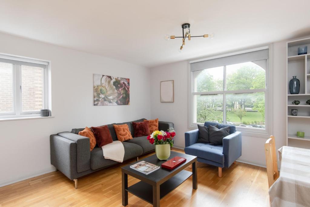 a living room with a couch and two chairs at Stunning Flat 5 min from Station in London