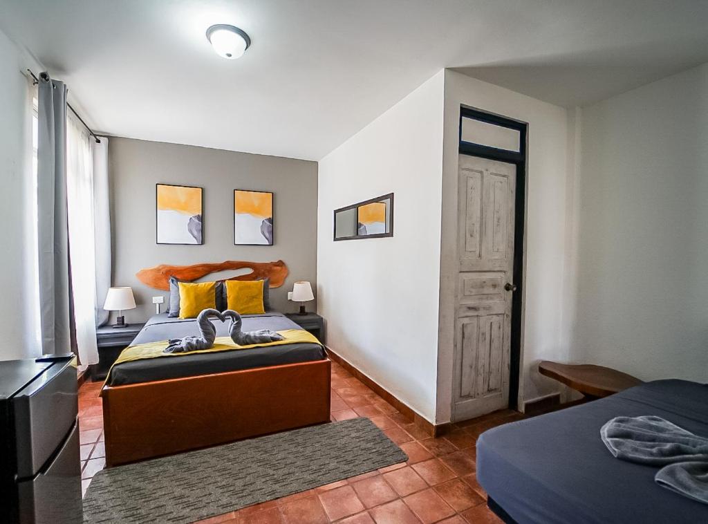 a bedroom with two beds and a door at La Flor de Coco in Sámara