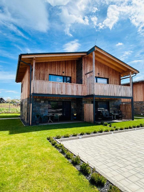 a large wooden house with a patio in front of it at Apartmán C1 - Slovenský Raj in Hrabušice