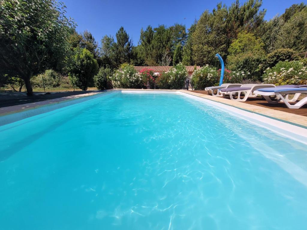 a swimming pool with blue water in a yard at Le Jas d Arcas in Le Martinet