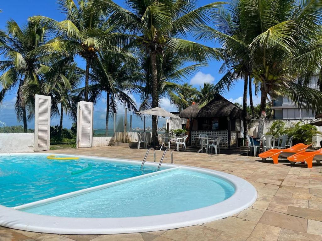 einen Pool in einem Resort mit Palmen in der Unterkunft NUMAR HOTEL in João Pessoa
