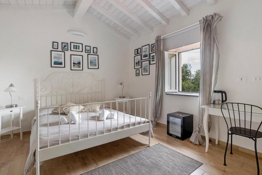 una camera con letto bianco, scrivania e finestra di Casa Conte Picedi Vineyars ad Arcola