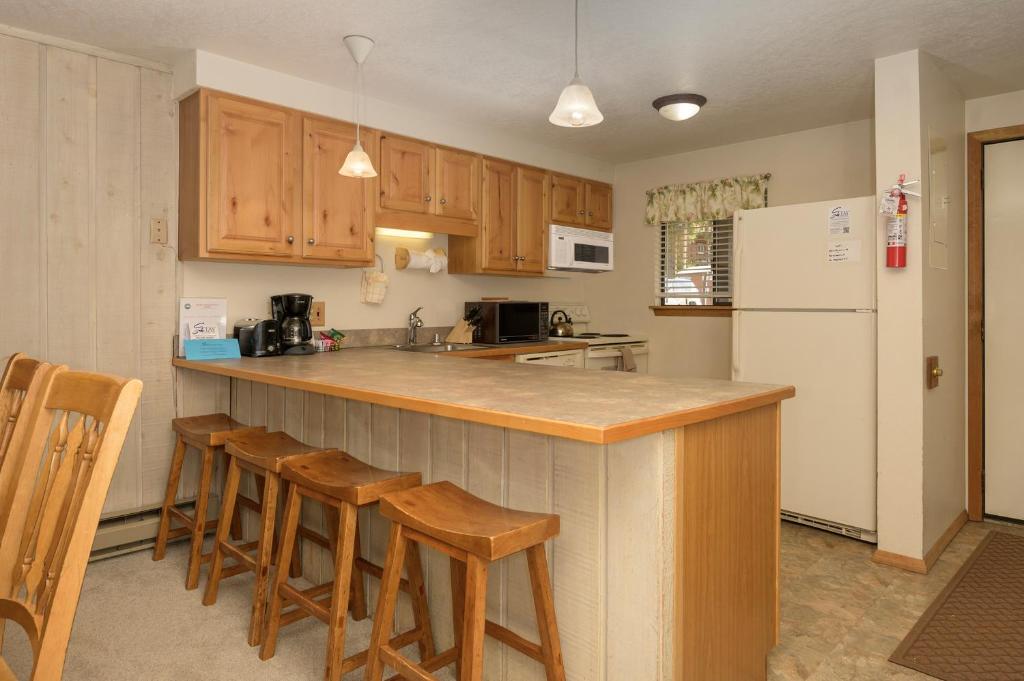 a kitchen with wooden cabinets and a white refrigerator at Beaver Village Unit #0712R in Winter Park
