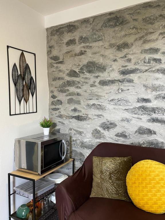 a living room with a couch and a stone wall at Cozy House in Funchal