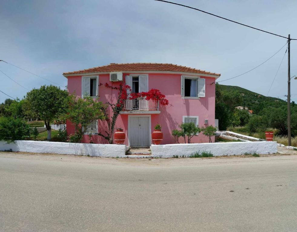 een roze huis aan de kant van de weg bij Traditional house in Ratzaklíon