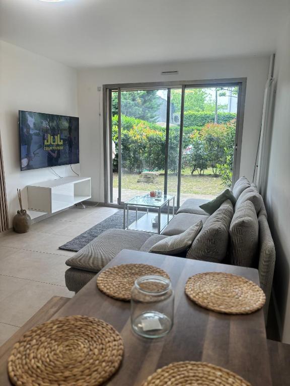 un salon avec un canapé et une table dans l'établissement Apparemment au bord du lac,10 min de Paris,12 min de stade France, à Épinay-sur-Seine