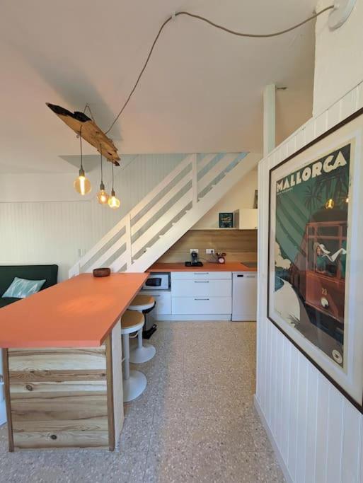 - une cuisine avec une table et un escalier dans une chambre dans l'établissement Maison de vacances - 4 chambres - Portiragnes-Plage, à Portiragnes