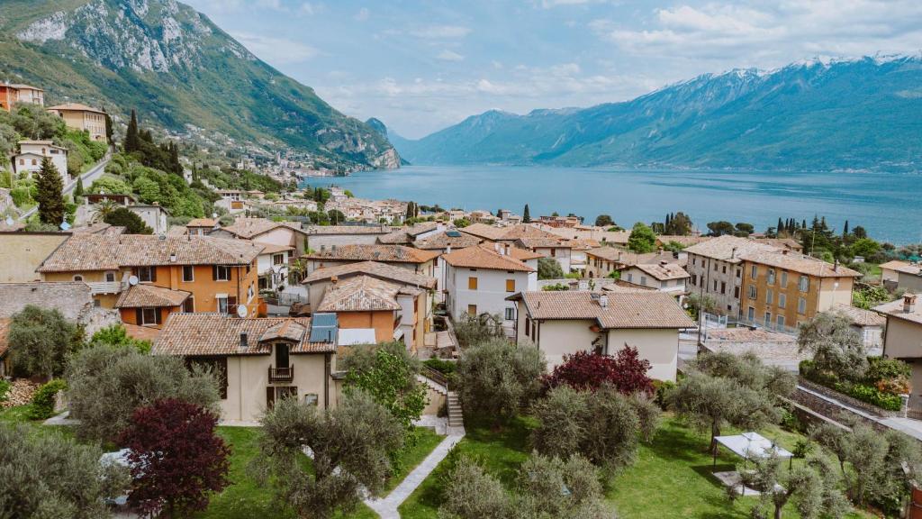 un pueblo con un lago y montañas en el fondo en Campolivo, en Gargnano
