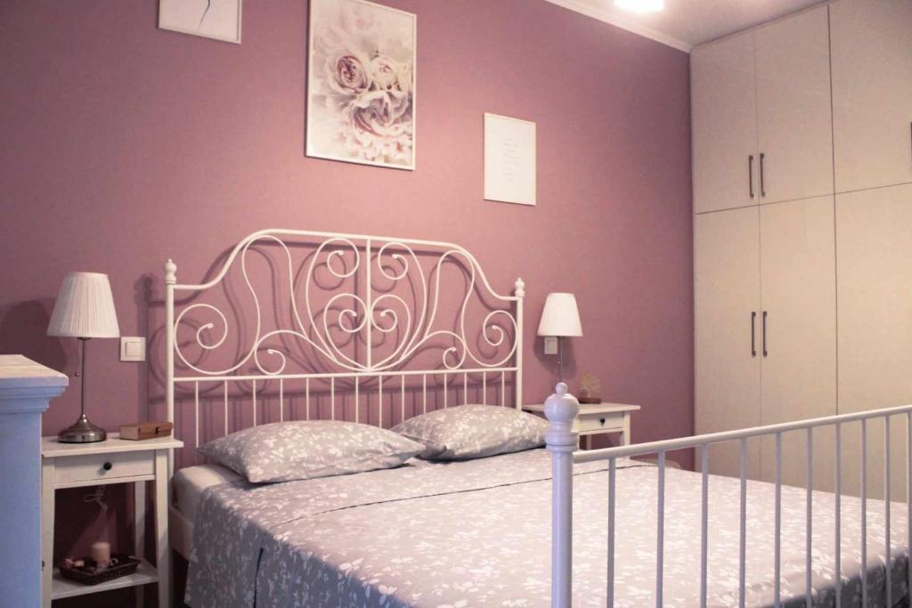 Schlafzimmer mit einem Bett und lila Wänden in der Unterkunft Agis home in Ágios Rókkos