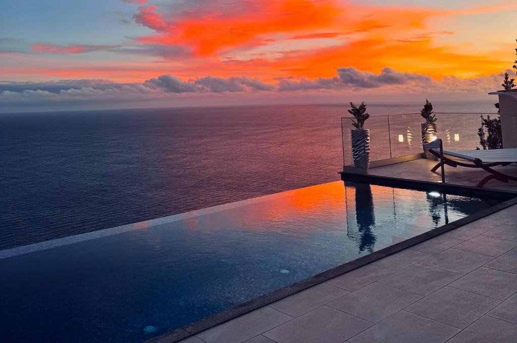 a swimming pool with a view of the ocean at Villa Pérola in Calheta