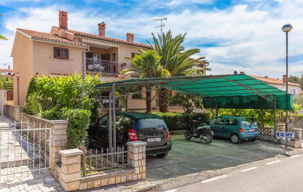 a parking lot with cars parked in front of a house at Emi in Poreč