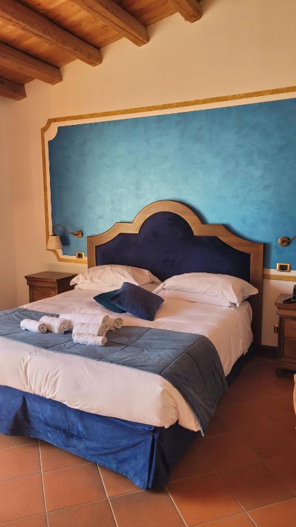 1 dormitorio con 1 cama grande y pared azul en Hotel Villa Lampedusa, en Palermo
