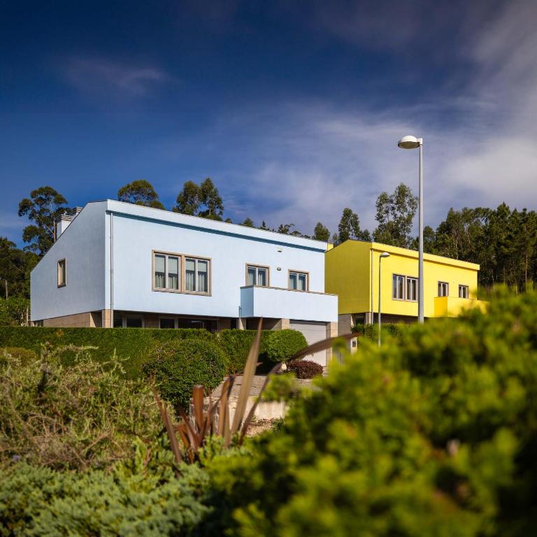 une maison blanche et jaune au sommet d'une colline dans l'établissement Outeiro Villas Resort, à Barcelos