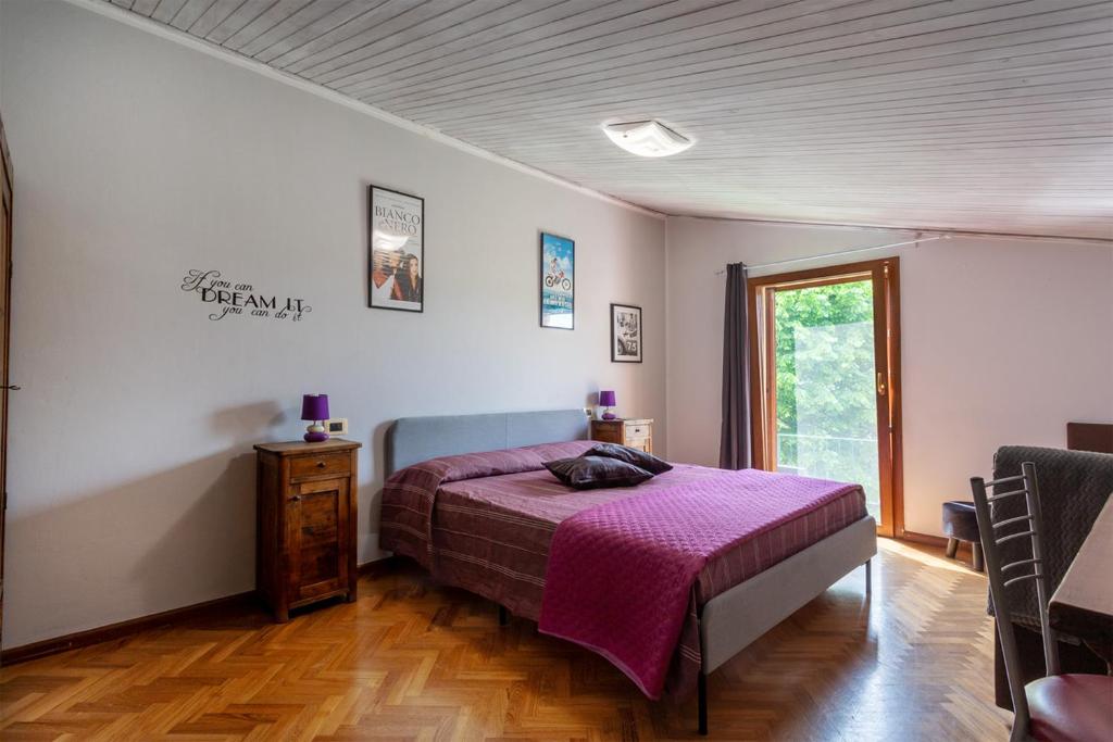 una camera con un letto e una coperta viola di Maxi Paradiso a Torricella