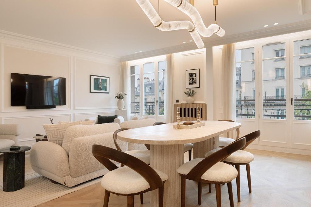 un salon avec une table, des chaises et un canapé dans l'établissement TheLander - Serviced Apartments in Champs Elysées, à Paris