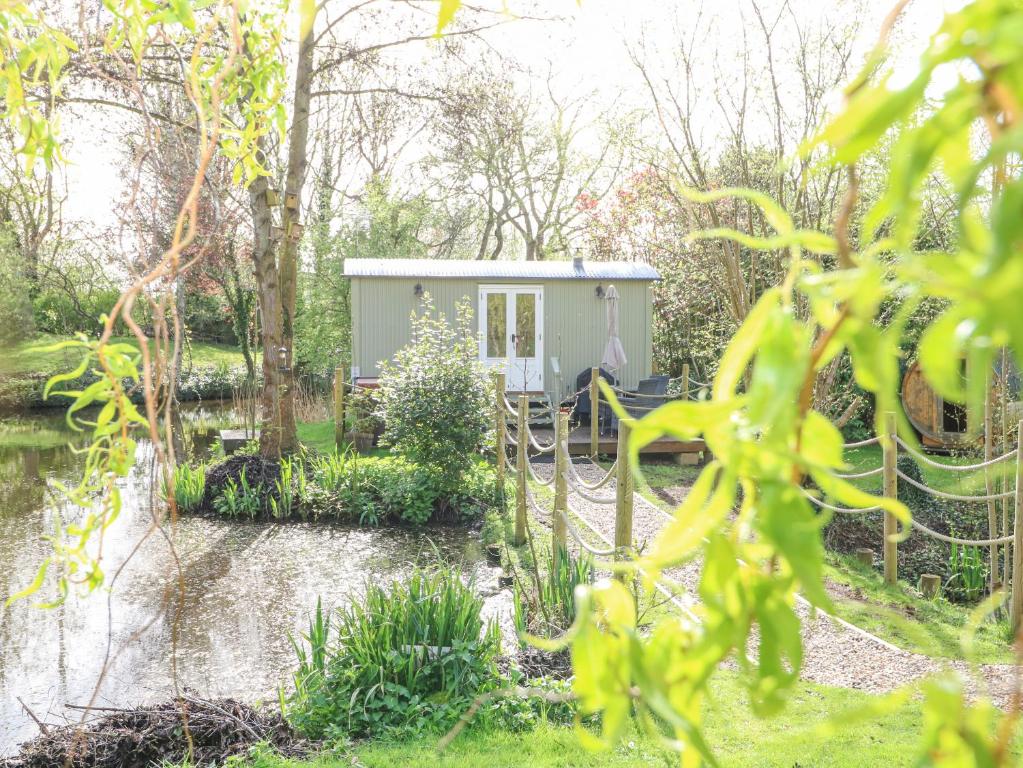 ein winziges Haus inmitten eines Gartens in der Unterkunft Damsel Shepherds Hut in Badwell Ash