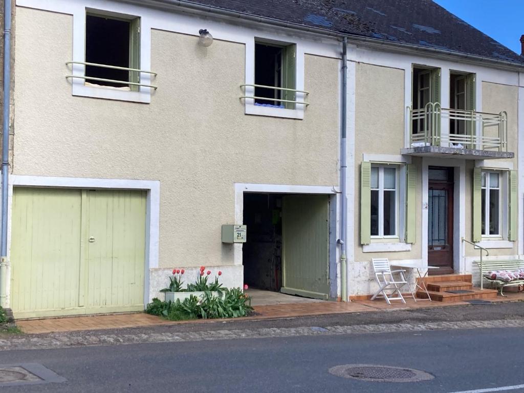 una casa con dos puertas de garaje en una calle en Chambre d'hote les frérots, en Lurcy-le-Bourg