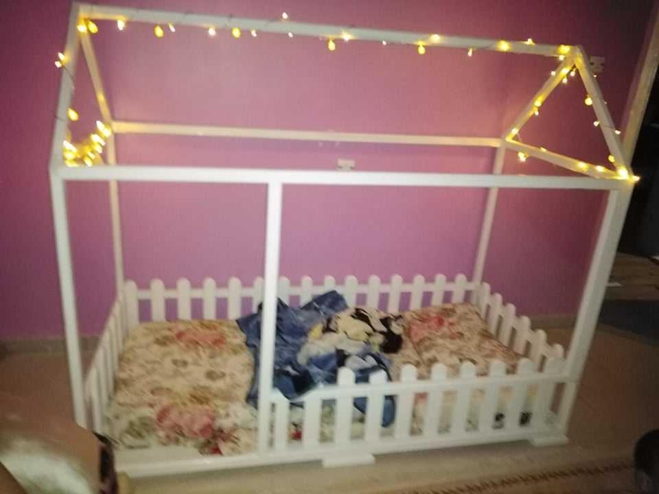ein weißes Kinderbett mit Beleuchtung darüber in der Unterkunft Mimi cheriti in Bordj Lutaud