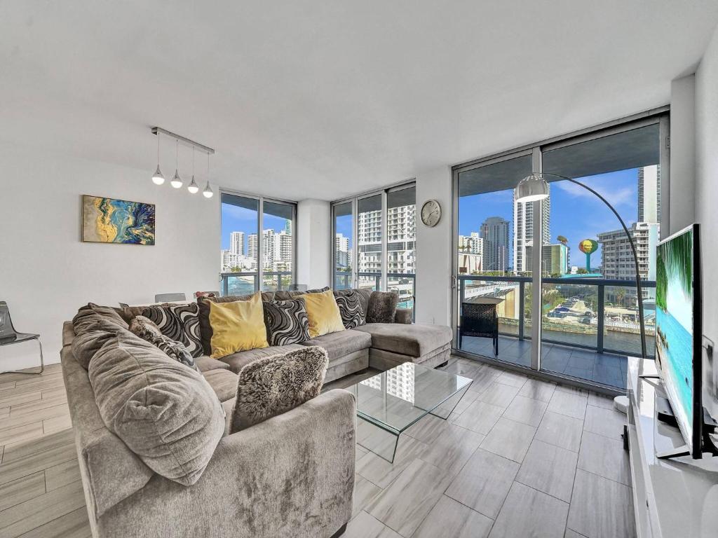 Una sala de estar con un sofá y un televisor. en Luxury Waterfront Suite, en Hallandale Beach