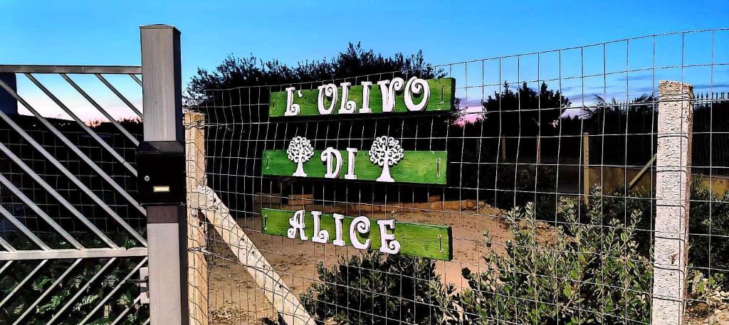 uma cerca com um sinal no topo de um edifício em L'ulivo di Alice em Marsala