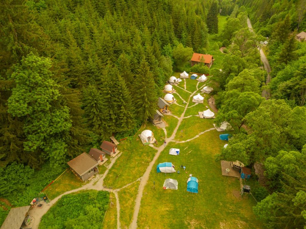 una vista aerea di un gruppo di tende in una foresta di Fain a Lunca Bradului