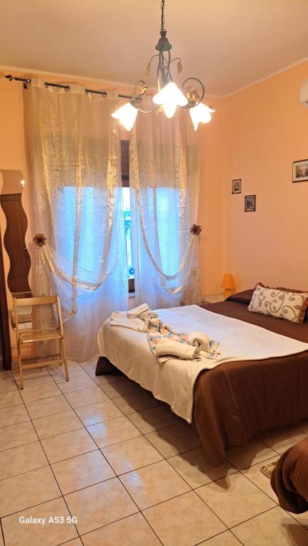 sypialnia z łóżkiem, krzesłem i oknem w obiekcie Casa Holiday Sea Etna Di Enza w mieście Linguaglossa