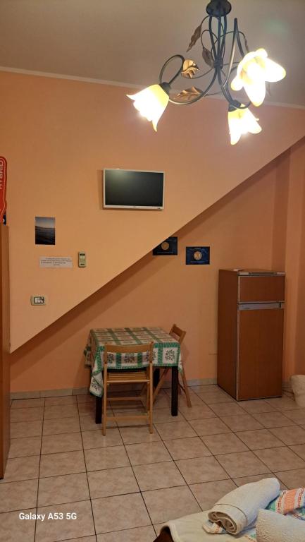 kuchnia ze stołem i telewizorem na ścianie w obiekcie Casa Holiday Sea Etna Di Enza w mieście Linguaglossa