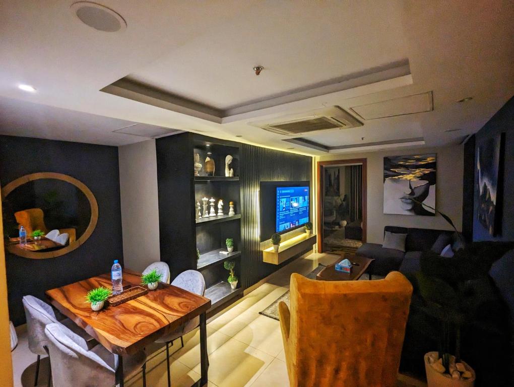 sala de estar con mesa y TV en Gold Crest Mall One bedroom Penthouse Apartment DHA Lahore, en Lahore