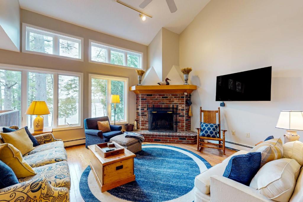 a living room with couches and a fireplace at Lake View by the Mountain in Bridgton