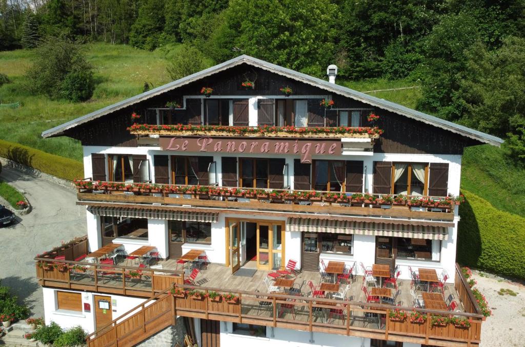 a building with a restaurant with chairs on it at Hôtel Chalet Le Panoramique in Mizoën