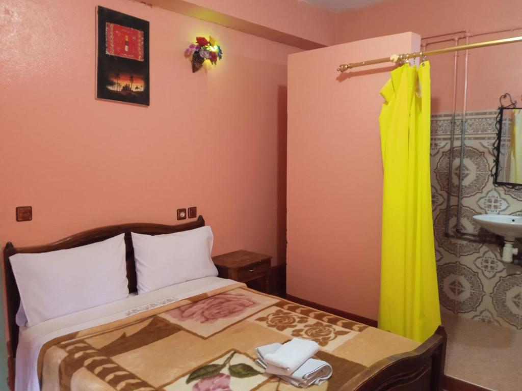 Dormitorio pequeño con cama y lavamanos en Auberge Camping Garde of Eden LE LAC, en Tinerhir
