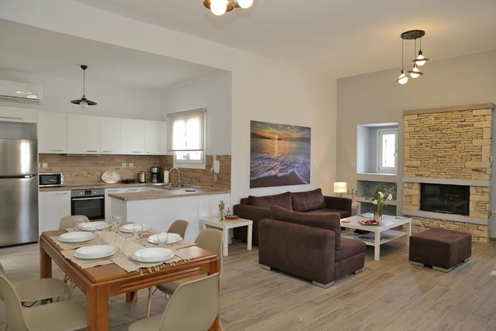 a kitchen and a living room with a table and chairs at Anchorage Andros Villa in Andros