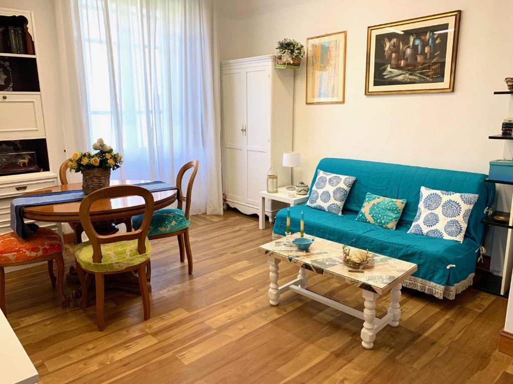 a living room with a blue couch and a table at Guest House A Due Passi in Olbia