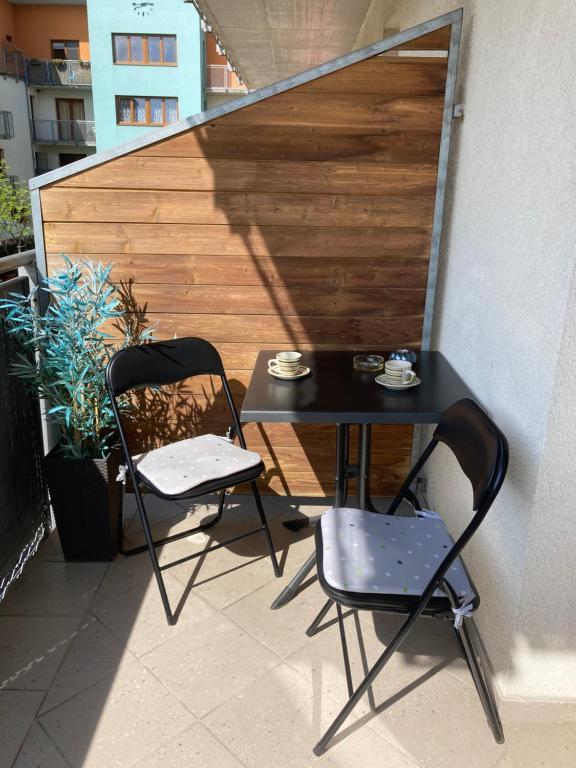 uma mesa preta e duas cadeiras numa varanda em Apartmán Janka em Oščadnica