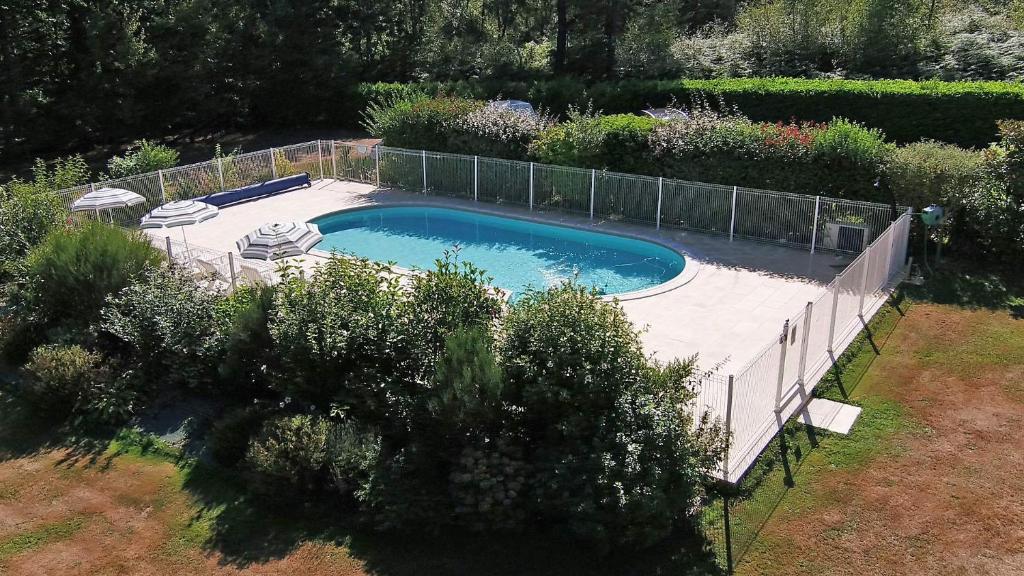 une piscine dans un jardin avec une clôture dans l'établissement Domaine du grand roc- Gîte 3- La sitelle, à Saint-Saud-Lacoussière