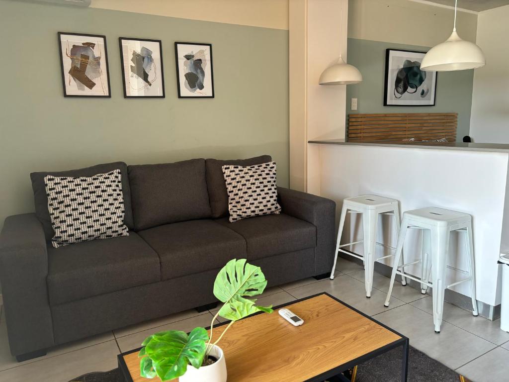 sala de estar con sofá y mesa en Coral Point Executive studio Apartment, en Umdloti