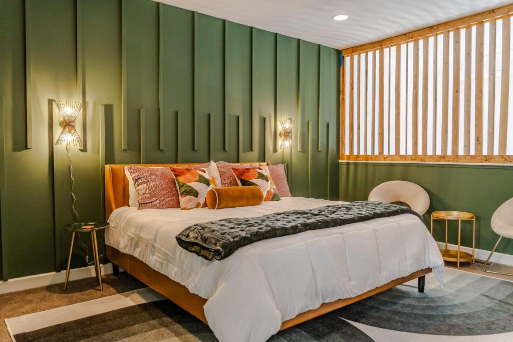 a bedroom with a large bed and green walls at Groovy Condo in the Vibrant NuLu District in Louisville