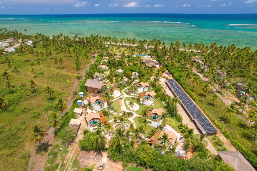 an aerial view of a resort with palm trees and the ocean at Pousada Reserva do Patacho in Pôrto de Pedras