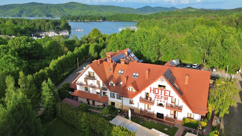 an aerial view of a large house with a lake at Zefir SPA in Polańczyk