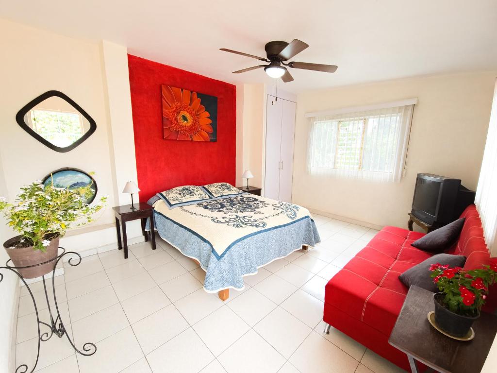 瓜達拉哈拉的住宿－Esquina del Pintor，一间卧室设有一张床和红色的墙壁