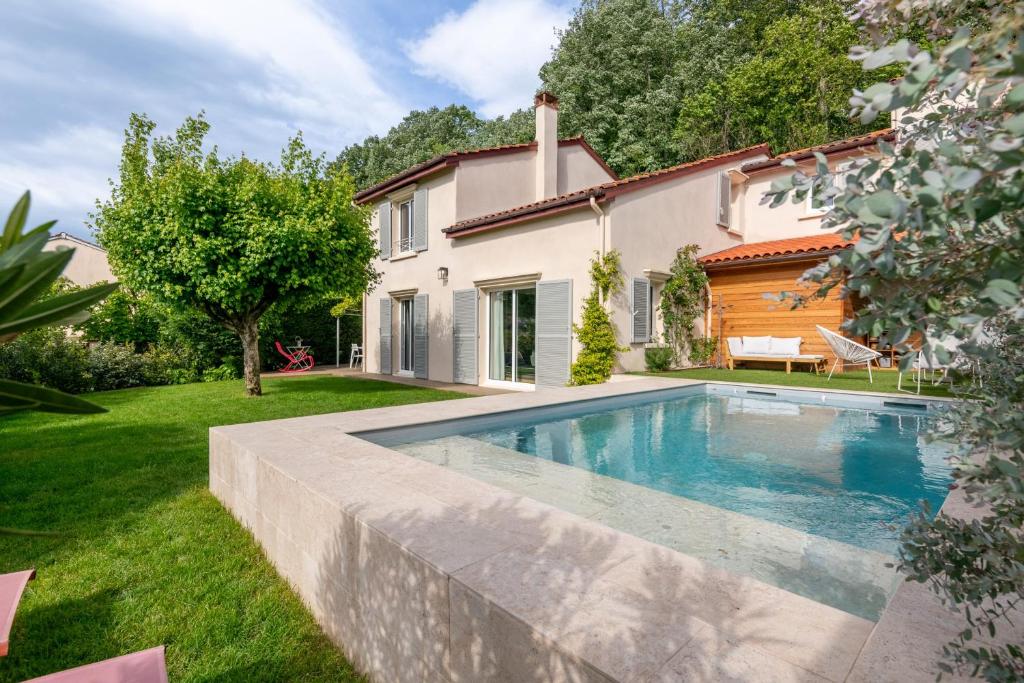 una piscina en un patio junto a una casa en Villa Juliette - Welkeys en Écully