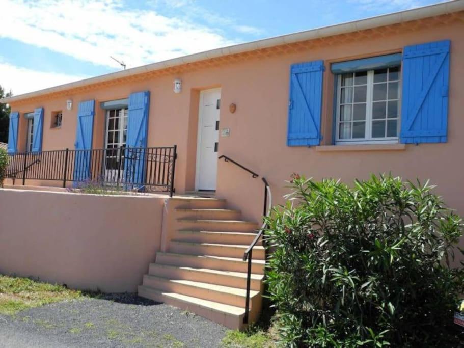 une maison avec des fenêtres et des escaliers bleus à volets dans l'établissement La Maison Alex, à Castelnau-de-Guers