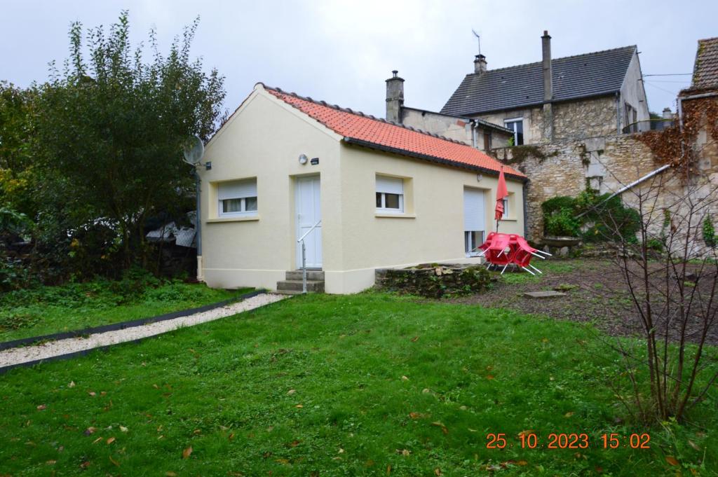 a white house with a red roof in a yard at Maisonette Vallée de l'Automne Streaming & Vinyles 