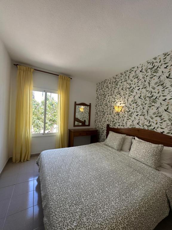 Un dormitorio con una cama grande y una ventana en Costa Azul Apartamento, en Adeje